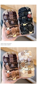 Detailed close-up of brown, black, and beige elastic hair tie sets in stylish boxes