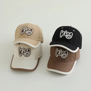 Detail showing kids baseball caps with kiy embroidery and contrast piping in four colors