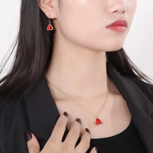 Golden triangle necklace and red crystal earrings set worn by a fashion model