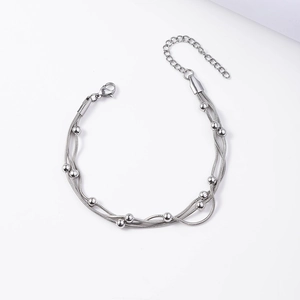 Close-up of triple-layered silver snake chain bracelet with metallic beads and clasp