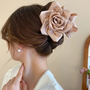 Détail d'une pince à cheveux rose en satin champagne portée pour une coiffure élégante