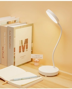 Close-up of white LED desk lamp with flexible neck and warm light on a wooden table
