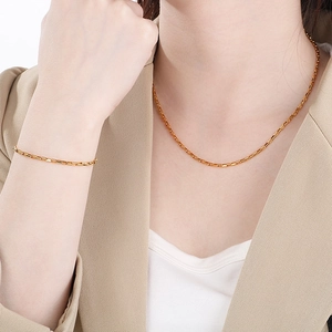 Detail showing the minimalist gold rectangle box chain necklace and bracelet on model