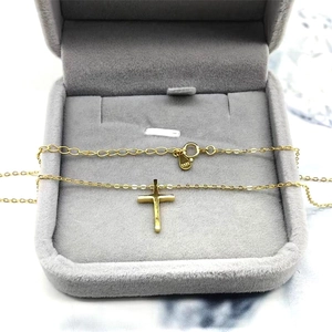 Close-up of S925 sterling silver golden cross necklace in a grey velvet gift box