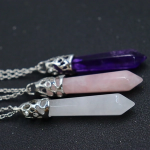 Close-up of hexagonal crystal point pendants in amethyst, rose quartz and clear quartz