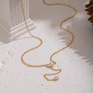 Détail du collier en Y en or 18 carats avec zircon et pétale sur pierre texturée