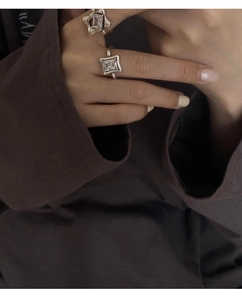 Detail showing two silver 925 rings with square diamonds worn on the finger