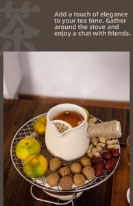 Detail of cream ceramic side-handle teapot on metal grill with roasted snacks and nuts