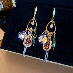 Close-up of vintage teardrop earrings with zircon accents and colorful chain tassels