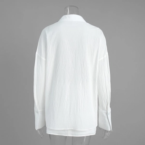 Detail view of the back of a white long-sleeved shirt with crinkled texture fabric
