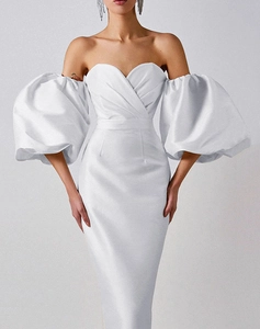 Detail of white off-shoulder satin dress with sweetheart neckline and puff sleeves