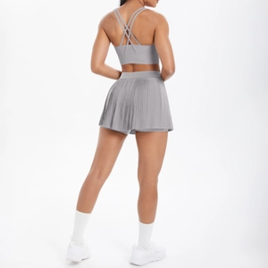 Détail du soutien-gorge de sport gris clair à dos croisé et jupe de tennis plissée assortie