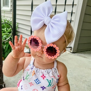 Pink flower sunglasses and white bow headband paired with luxury print baby swimwear