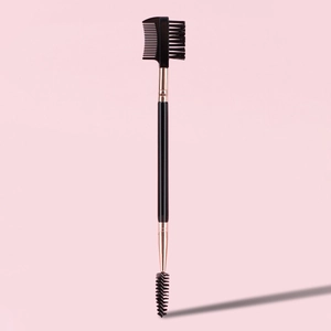 Close-up of dual-ended eyebrow and eyelash brush with pink handle and rose gold ferrule