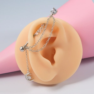 Boucle d'oreille chaîne argentée avec lune, étoiles et zircons sur support rose