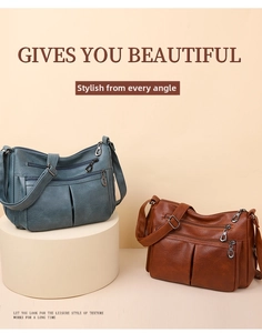 Detail view of large multi-compartment crossbody bags in blue and brown leather tones