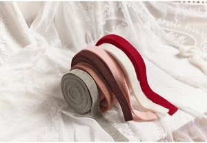 Macro detail of thick wool ribbons in multiple colors on a white lace background