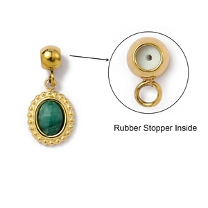 Detail of oval green stone pendant in gold frame with rubber stopper inside beads