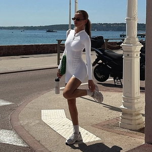 Detail view of a white ribbed knit slim fit long sleeve romper worn at the beach