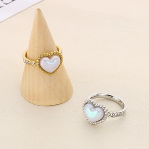 Detail of heart shell rings in gold and silver finishes with sparkling accents