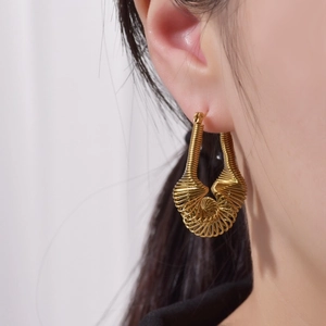 Detaillierte Nahaufnahme eines Models mit goldenen Spiralspulen-Ohrringen