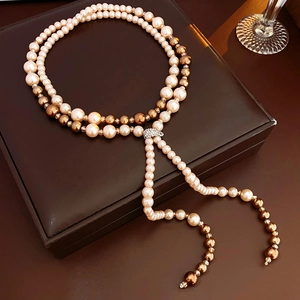 Close-up of vintage multi-layer pearl necklace with rhinestones on leather display