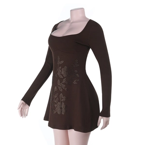 Détail de fleurs en strass sur une mini-robe moulante marron à manches longues