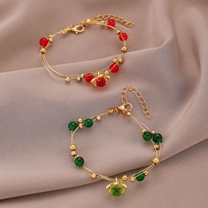 Primer plano de pulseras de cuentas vintage con gemas rojas y verdes en seda