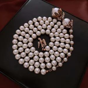 Elegante collana di perle con pendente a forma di aquila dorata e dettagli in strass