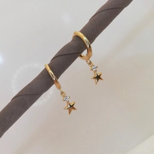 Macro shot of gold star drop earrings with sparkling crystals on S925 silver needles