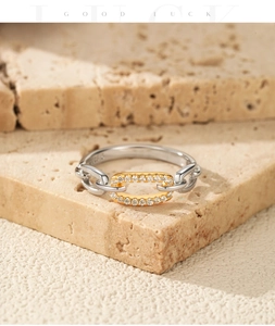 Gros plan d'une bague en argent S925 avec maillon doré et pavé de diamants en zircone cubique