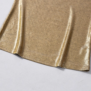 Makroaufnahme der metallisch goldenen Stoffstruktur und Saumdetails mit feinem Gewebe