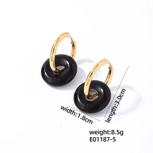 Détail de boucles d'oreilles minimalistes dorées avec anneaux noirs de 3,0 cm sur 1,8 cm