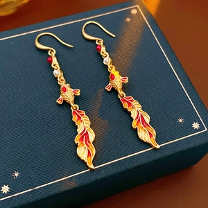 Detailed close-up of vintage koi fish earrings with red enamel and white pearls