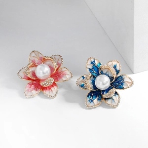 Elegant floral brooches with pink and blue enamel petals, pearls, and crystals in gold