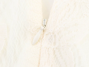 Close-up of invisible zipper detail and intricate white lace floral embroidery on the top
