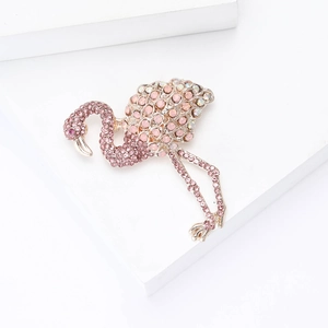Detail view of pink rhinestone flamingo brooch with vibrant crystals on metal base