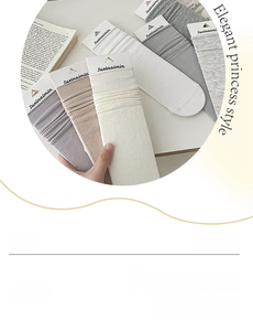 Close-up of knit cotton socks with vertical ribbed texture in soft neutral pastel tones