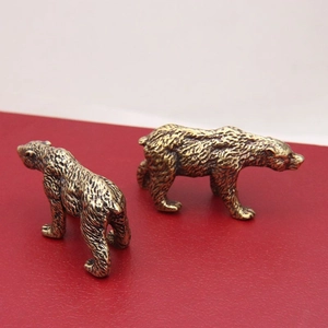Antique brass polar bear statues with detailed fur texture on a red base