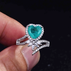Detailed view of heart-shaped emerald green gemstone ring with halo diamond setting
