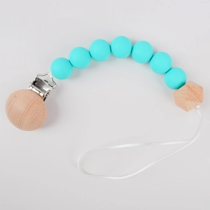 Silicone and beech wood baby pacifier clip with turquoise beads on gray background
