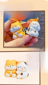 Close-up of magnetic Shiba Inu and cat couple keychains showing the suction feature
