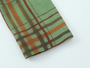 Detail of green and orange plaid fabric showing tight woven texture and pattern