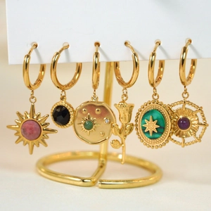 Set mit sechs Vintage-Goldohrringen mit Sonnenanhängern und Türkissteinen auf Ständer