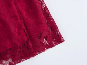 Détail de la dentelle florale rouge avec des bords festonnés sur la robe