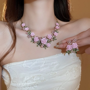 Close-up of pink rose jewelry set with pearls and rhinestones on a female model