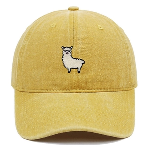 Detailed embroidery of a white alpaca on a washed yellow cotton baseball cap with stitching