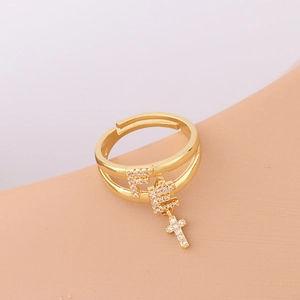 Detail of gold double-layer pin ring with cross charms and micro-set white zircon stones