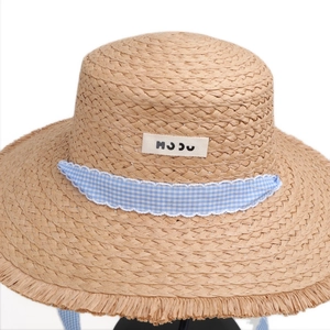 Strohhut mit breiter ausgefranster Krempe und blauem Karoband für den Sommerstrand
