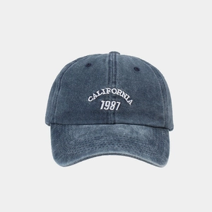 Detailed view of California 1987 embroidery on washed denim blue baseball cap